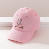 Top-down view of the Pusheen Pink Cap. The light pink dad hat has an embroidery of Pusheen holding a cherry dessert that will show on the wearer's forehead area. 