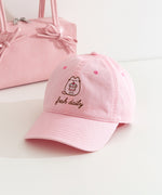 Fresh Daily Pusheen Sweets pink cap. The cat holds a cherry tiered mini cake. 