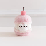Front view of the Pusheen Sweets Cherry Macaron Plush. The removable white Pusheen plush sits within a macaron environment with a light pink cherry at the very top.  