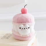 Front view of the Cherry Macaron Pusheen Plush. The pink and white plush environment mimics the look of a macaron with whipped white filling.  