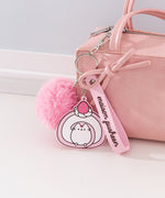 Chunky Pusheen Keychain attached to a pink purse. Pusheen the Cat is transformed inot a pink and white swiss roll topped with a pink and white strawberry and a white whipped cream dollop.