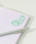 Model places the Pusheen notebook in a file divider to show size of the the mint green sweets-themed notebook.
