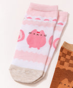 Pusheen Sweets 3-Pack Ankle Socks in their top cardboard packing lying on a pink surface. The strawberry-themed socks are on top of the set of 3.