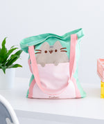 Back view of Pusheen Deluxe Tote Bag. The mint tote bag has pink handles that extend down the entire body of the bag. 