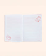 Interior view of the plush notebook. The inside cover features a pink checkered print with bananas and Pusheen Bananas in a scattered pattern.