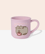 Back view of Pusheen pink mug. The light-pink cup features a grey and brown graphic of Pusheen relaxing with her own hot beverage in a pink mug. The graphic on the back matches the graphic on the front. 