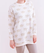 Close-up view of the Pusheen Loungewear Top’s all over print. The graphics of Pusheen the Cat show her grey standing body and leggings accented with brown features: tail stripes, back stripes, head stripes, eyes, mouth, and whiskers. 