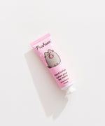 Close-up of the Pusheen hand lotion tube that is strawberry scented and has pink packaging. 
