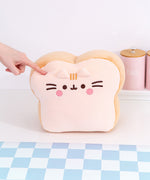Back view of the Pusheen's Kitchen White Bread Squisheen Plush. The back of the bread slice plush features Pusheen's two back stripes that matches the light-brown color of the side of plush. Towards the bottom of the plush is Pusheen's striped tail alternating the colors of light cream and light brown.