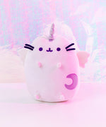 Back view of the Super Pusheenicorn Plush on top of a white square pedestal, in front of a light purple background.