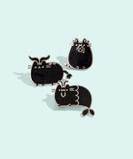 Group photo of three of the metallic Pusheen horoscope pins, featuring Pusheen as the three horoscope signs, Capricorn, Taurus, and Virgo